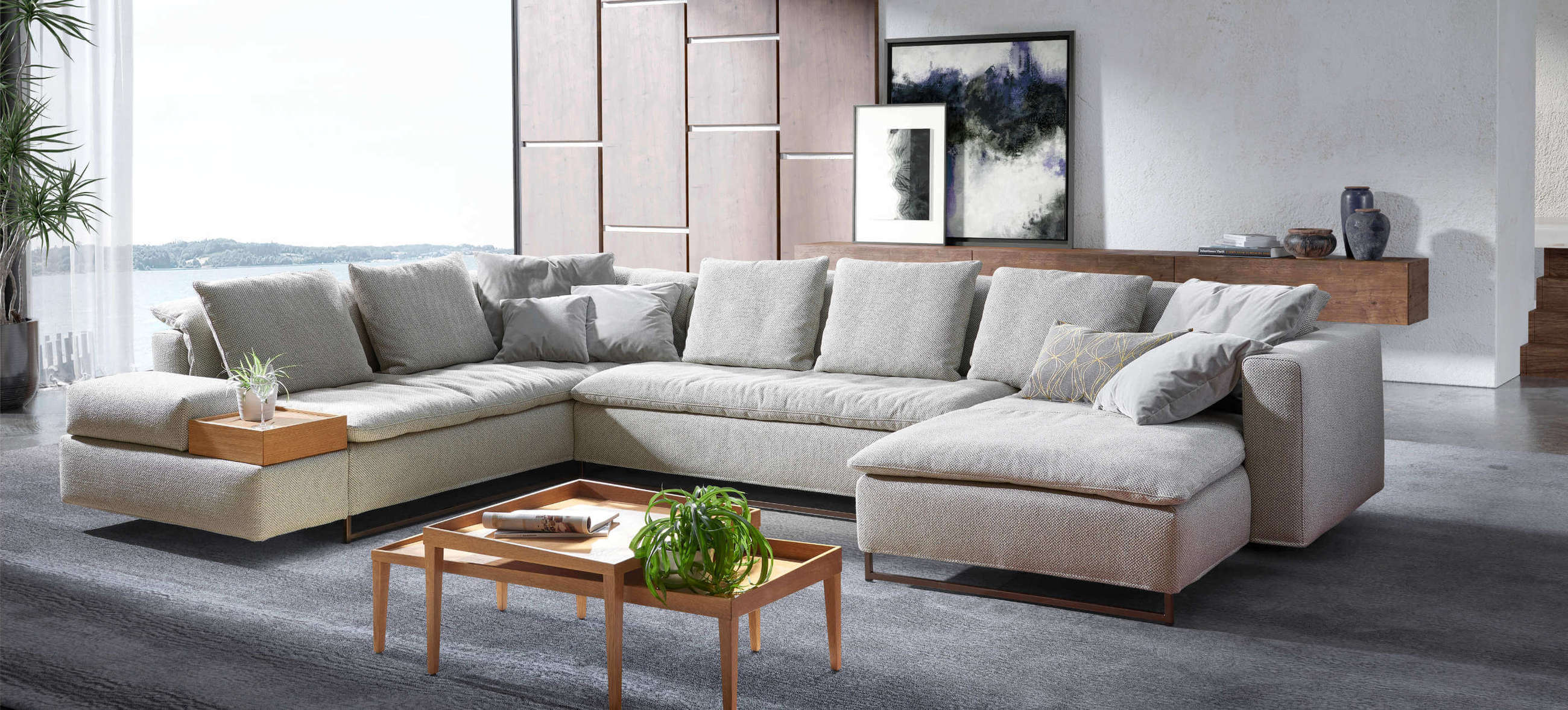 Großes Isla Ecksofa von Signet als Wohnlandschaft im U-Format. Ecksofa Isla von Signet in einem modernen Wohnzimmer, kombiniert mit Holzdetails und Kissen für stilvollen Komfort