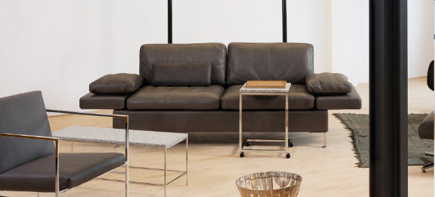 Bruehl Sofa Alba mit Lederbezug, klappbaren Armlehnen, weichen Polster und Metallfüßen. 