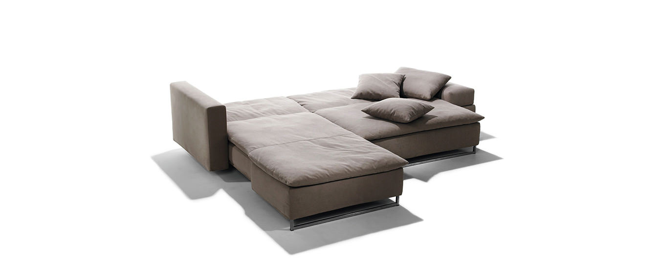 Ausgeklapptes Isla Ecksofa von Signet – Schlafsofa in Braun. Ausgeklapptes Isla Ecksofa von Signet in braunem Stoff mit großzügiger Liegefläche und Edelstahlfüßen.